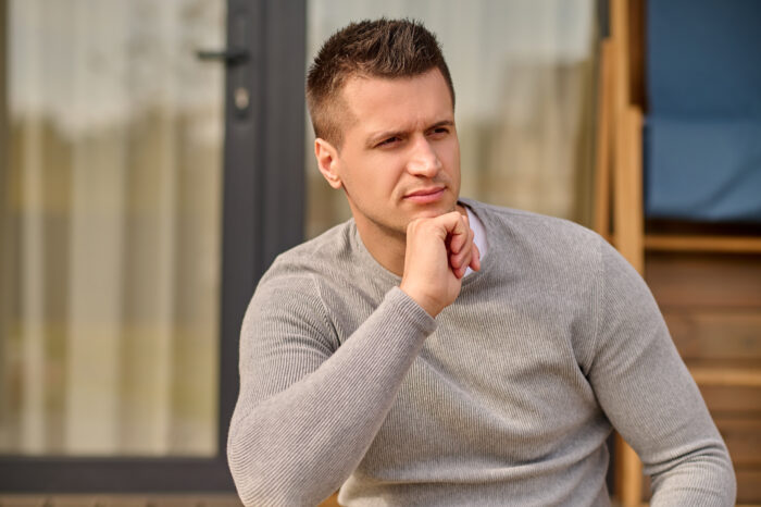 Man looks contemplative sitting on porch, reflecting on entitled bride incident Man looks contemplative sitting on porch, reflecting on entitled bride incident
