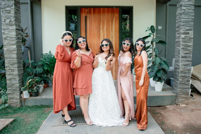 Bride with bridesmaids wearing sunglasses posing for wedding photos Bride with bridesmaids wearing sunglasses posing for wedding photos