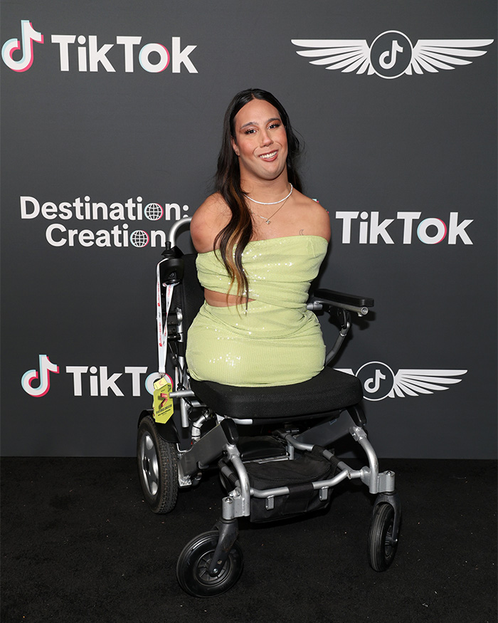 Trans influencer born without limbs posing in a light green dress in a wheelchair Trans influencer born without limbs posing in a light green dress in a wheelchair