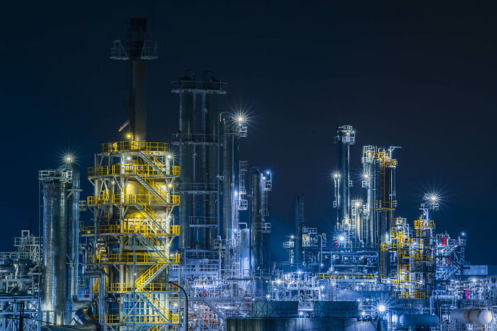 Night view of an illuminated industrial refinery, highlighting the beauty of buildings and spaces.