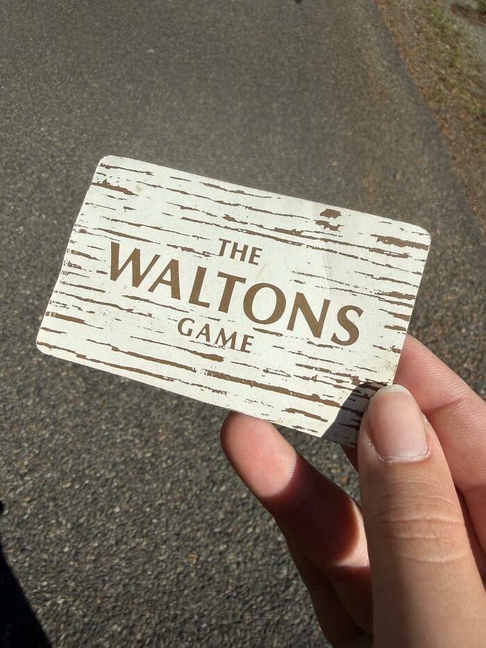 A person holding a game card outdoors as an example of a found paper item.