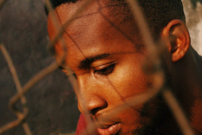 A thoughtful man behind a fence reflecting on his relationship and whether he should marry his fiance. A thoughtful man behind a fence reflecting on his relationship and whether he should marry his fiance.