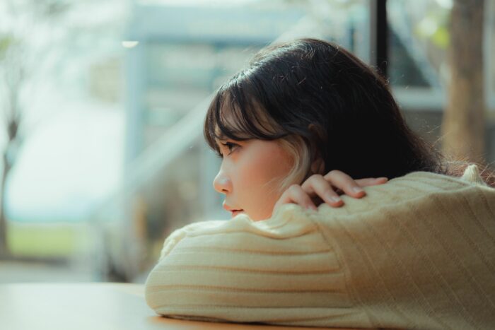 A sad, thoughtful woman leaning her head on her arms, representing the heartbroken fiancé. A sad, thoughtful woman leaning her head on her arms, representing the heartbroken fiancé.