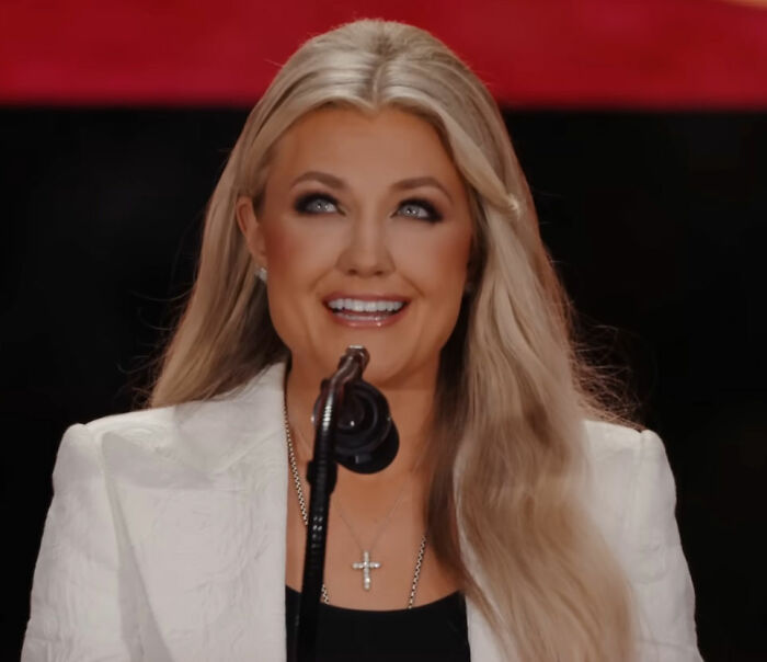 Erika Kirk wearing a white blazer and cross necklace in viral photos. Erika Kirk wearing a white blazer and cross necklace in viral photos.
