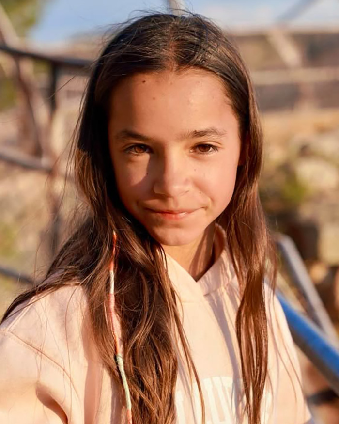 Fiona, daughter of Chad Lowe's friend, smiling gently for a portrait outdoors.