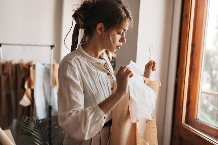A young woman carefully looking at clothing options to find things she wishes she had figured out sooner.