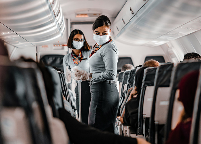 Flight crew members acting swiftly inside an airplane cabin with passengers. Flight crew members acting swiftly inside an airplane cabin with passengers.