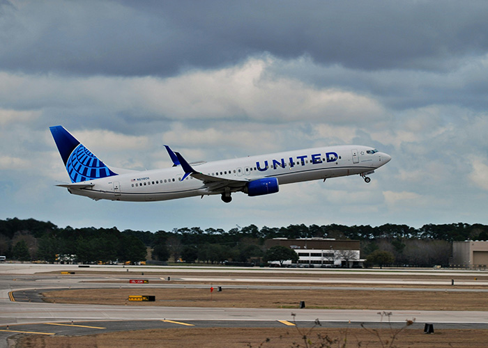 A United Airlines flight taking off against a cloudy sky. A United Airlines flight taking off against a cloudy sky.