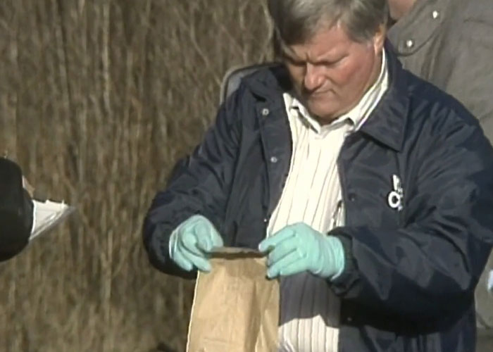 A forensic officer in gloves collects evidence related to the Christa Pike investigation
