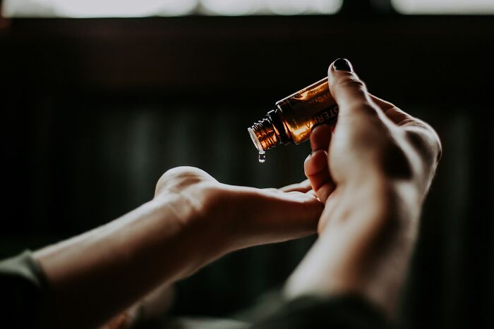 Dropping essential oil onto hand for practical life hacks use