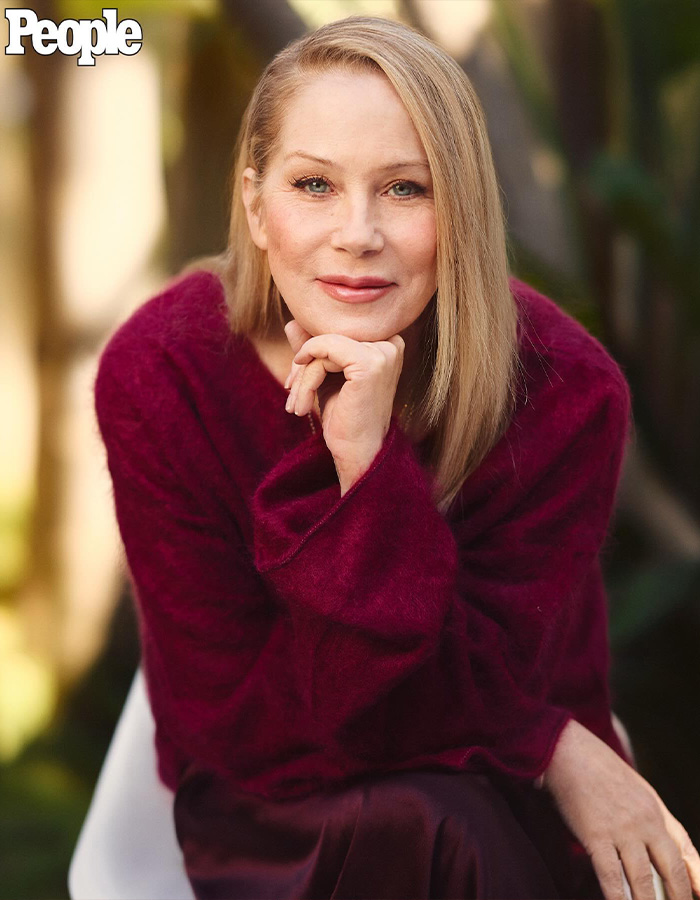 Christina Applegate posing for a portrait in a maroon sweater. Christina Applegate posing for a portrait in a maroon sweater.