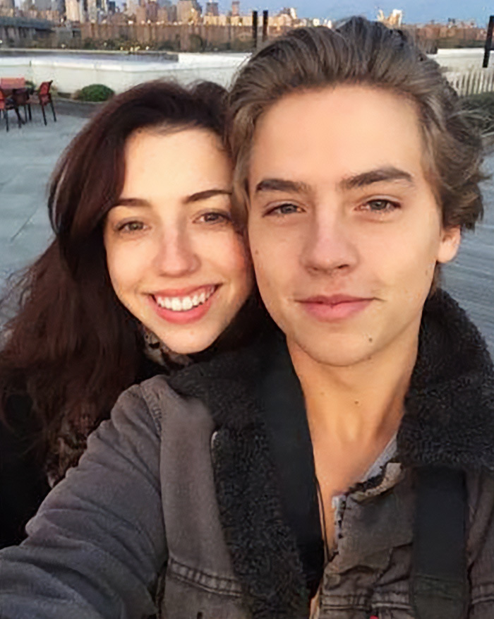 Cole Sprouse smiling with a female friend outdoors