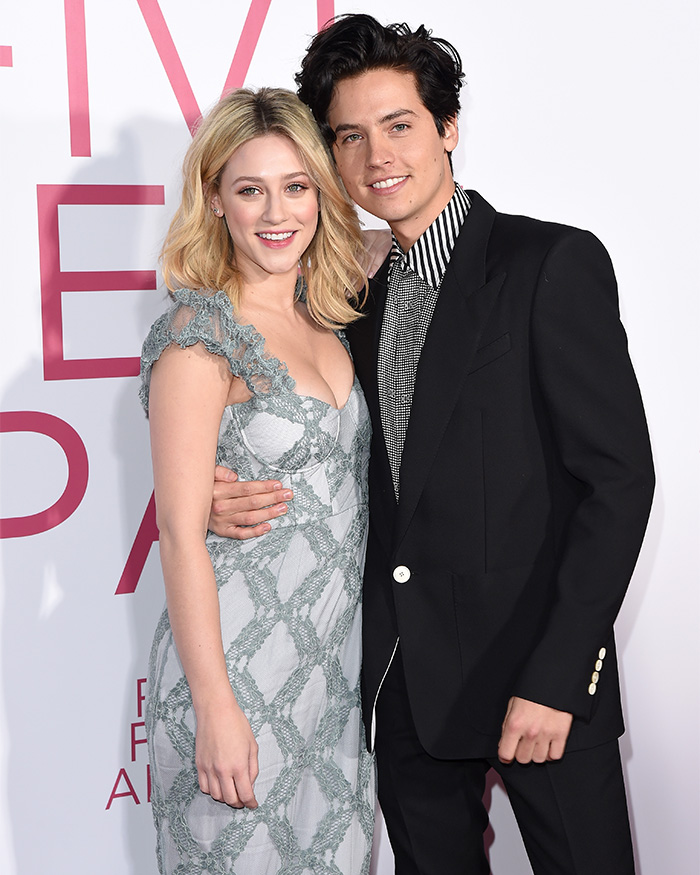 Cole Sprouse and Lili Reinhart smiling together at an event