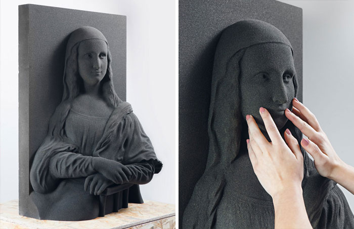 A 3D printer tactile Mona Lisa painting replica created for the blind being touched by hands