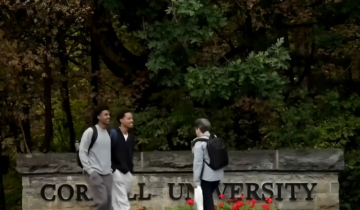 Students standing near the Cornell University entrance sign