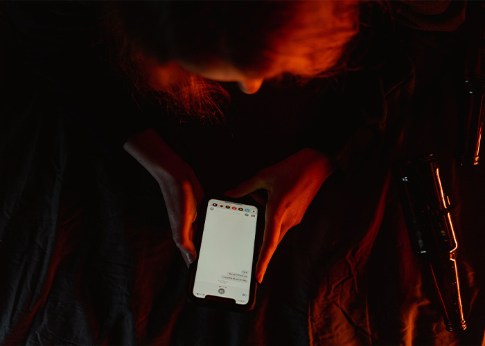 Person holding phone showing screen in dark room for Cornell 7 case Person holding phone showing screen in dark room for Cornell 7 case
