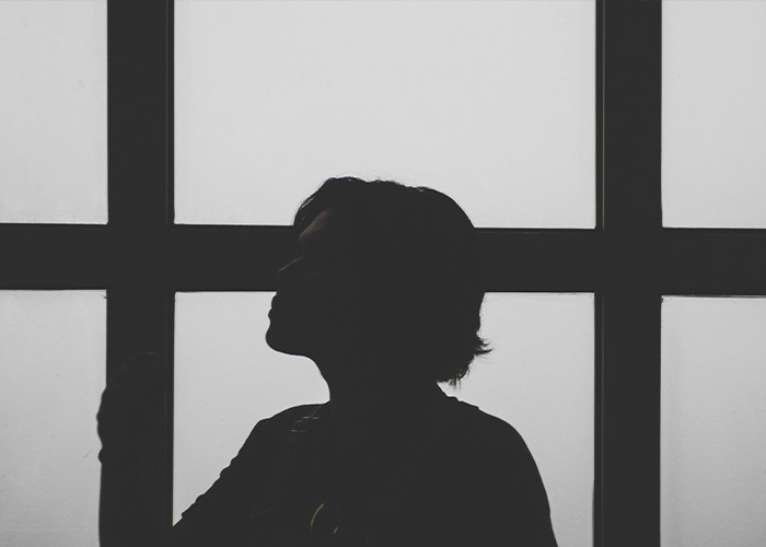 Silhouette of person in front of window symbolizing silence in Cornell case Silhouette of person in front of window symbolizing silence in Cornell case