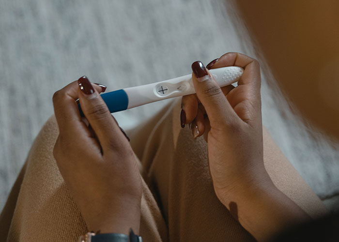 A woman holding a positive test stick, illustrating how a woman trick BF into believing she is pregnant. A woman holding a positive test stick, illustrating how a woman trick BF into believing she is pregnant.