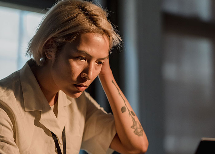 A thoughtful person leaning on their arm while reading about a woman tricking her BF into believing she is pregnant. A thoughtful person leaning on their arm while reading about a woman tricking her BF into believing she is pregnant.