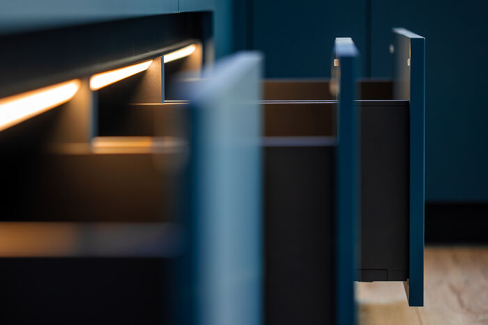 Open illuminated kitchen drawers presenting a spooky dark background ambiance