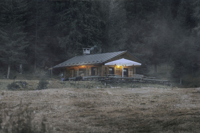 An isolated cabin in dark woods, illustrating spooky things people experienced outdoors.
