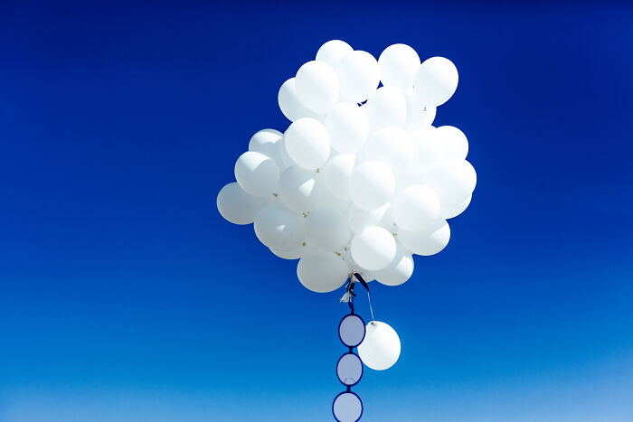 White balloons floating against clear blue sky creepy stories