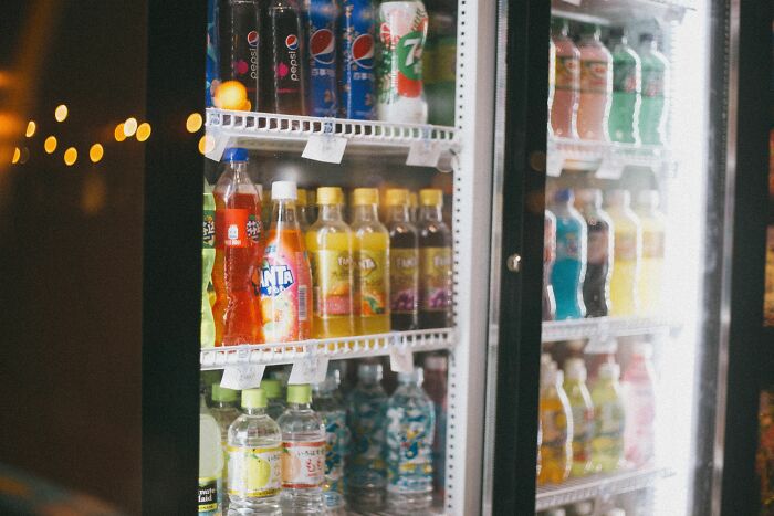 A brightly lit beverage cooler in a store operating during the night