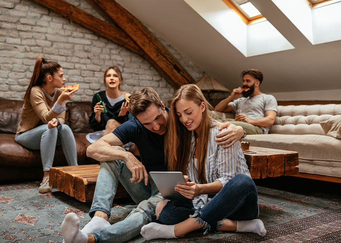 A group of young adults socializes indoors with pizza, representing family before women betray SIL. A group of young adults socializes indoors with pizza, representing family before women betray SIL.
