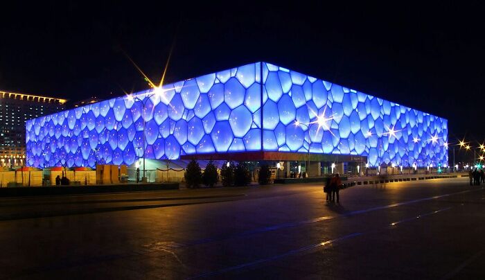 Blue illuminated structure with hexagonal patterns at night strange buildings