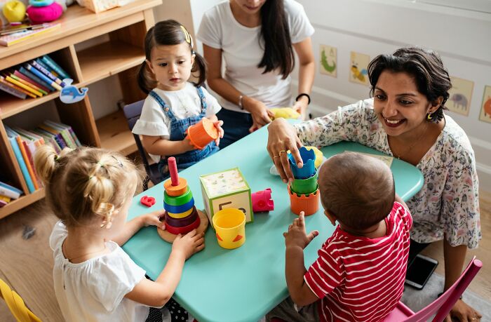 Children playing with toys near adults, highlighting family feuds over childcare.