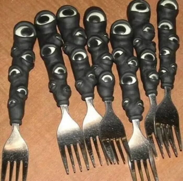 Cursed forks with black handles covered in many eyes surreal image