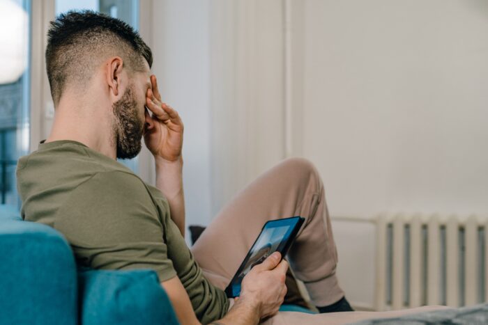 Stressed husband holding a tablet after learning his wife sabotaged stepchild food.