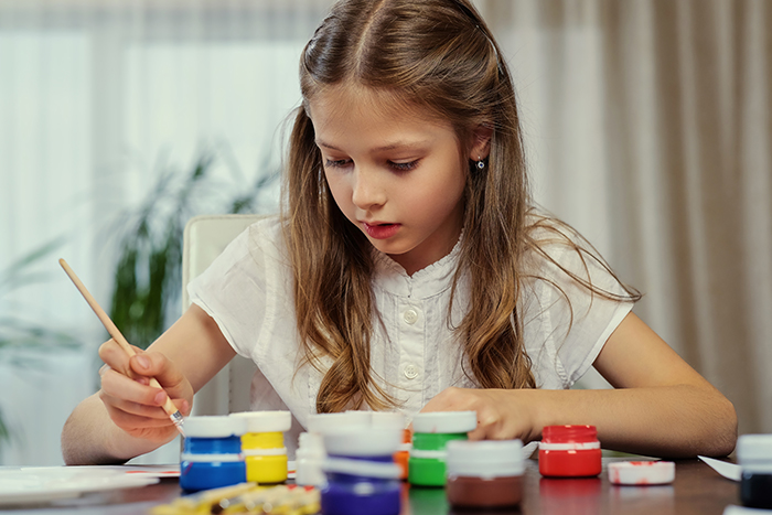 A young girl painting with watercolors, representing a daughter who wanted her dad to pay classes A young girl painting with watercolors, representing a daughter who wanted her dad to pay classes