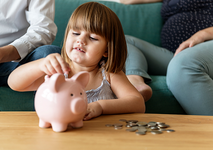 A little girl saves coins in a piggy bank illustrating lessons of dad-shamed-daughter-pay-classes A little girl saves coins in a piggy bank illustrating lessons of dad-shamed-daughter-pay-classes