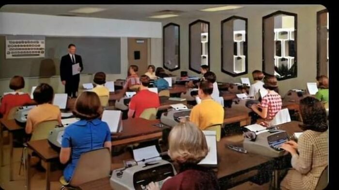 Vintage classroom with students on typewriters, recalling nostalgic photos from retro school days.