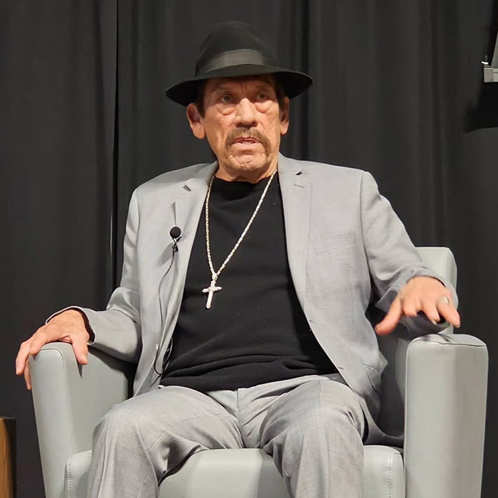 82-year-old action hero Danny Trejo seated in gray suit and hat during interview 82-year-old action hero Danny Trejo seated in gray suit and hat during interview