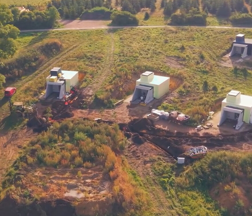 Aerial view of sensory deprivation experiment pods in a grassy field surrounded by trees Aerial view of sensory deprivation experiment pods in a grassy field surrounded by trees