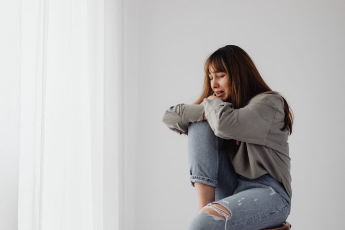 Distressed young woman crying in grief after a daughter’s cruel outburst tears family apart. Distressed young woman crying in grief after a daughter’s cruel outburst tears family apart.