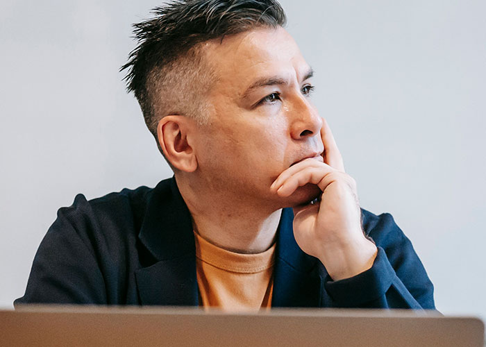 A thoughtful man looking into the distance, pondering strange online mysteries.
