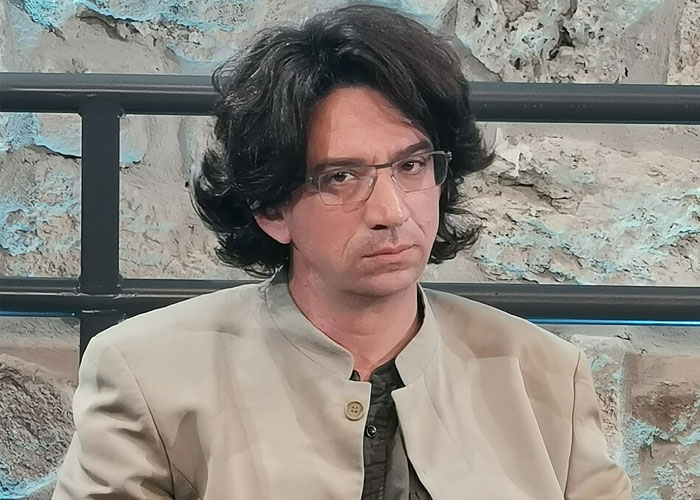 A dark-haired man in glasses who looks like he is investigating strange online mysteries.