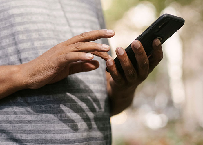 Close up of a person using a smartphone to research strange online mysteries.