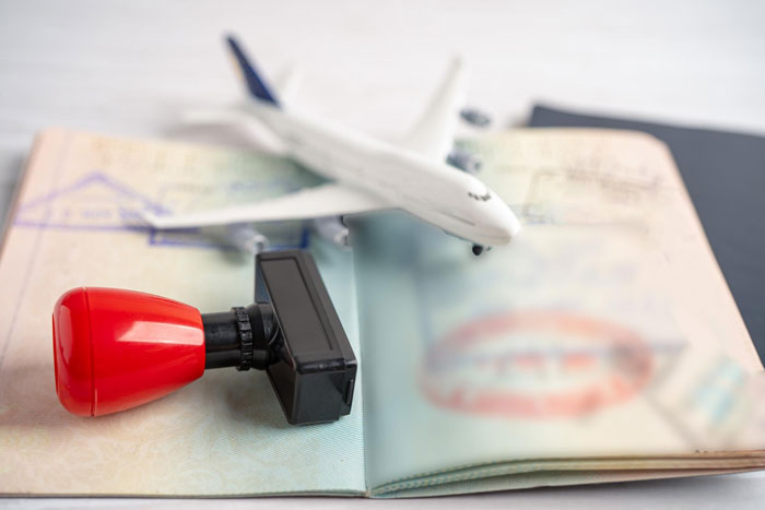 A passport, stamp, and toy airplane representing travel issues after a flight diverted due to a dad who yells. A passport, stamp, and toy airplane representing travel issues after a flight diverted due to a dad who yells.