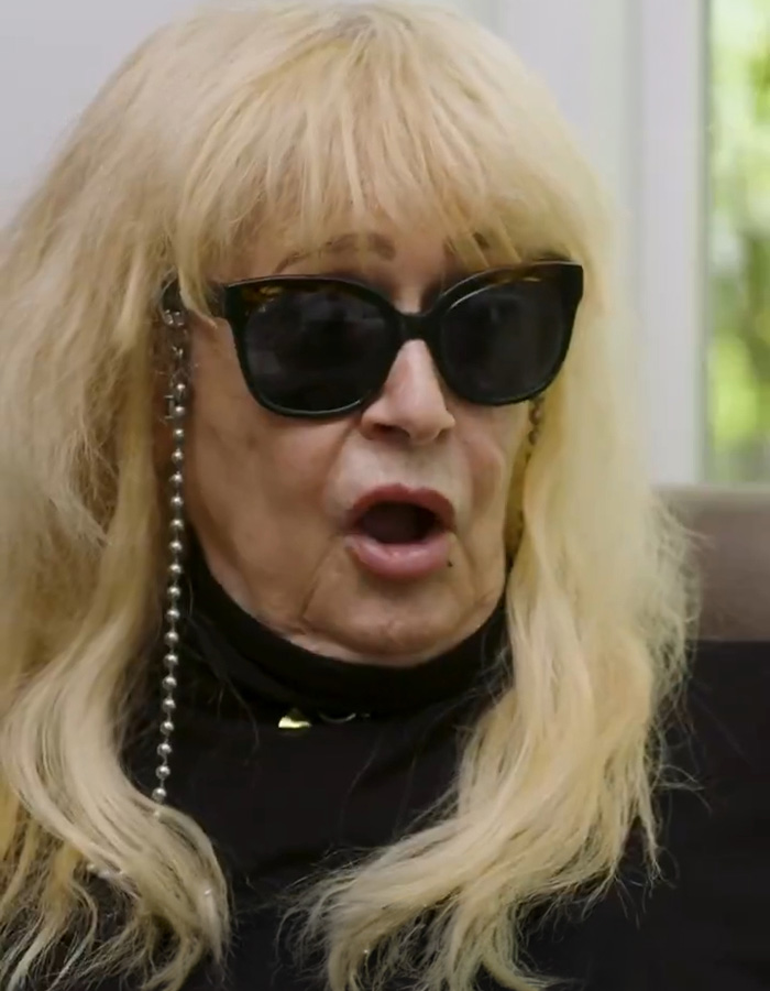 Older woman wearing sunglasses discussing Jennifer Aniston inappropriate gift claim Older woman wearing sunglasses discussing Jennifer Aniston inappropriate gift claim