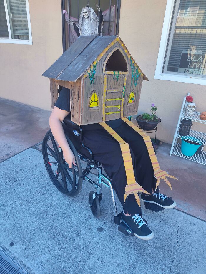 Person in a wheelchair wearing a creative Baba Yaga hut costume for Halloween.