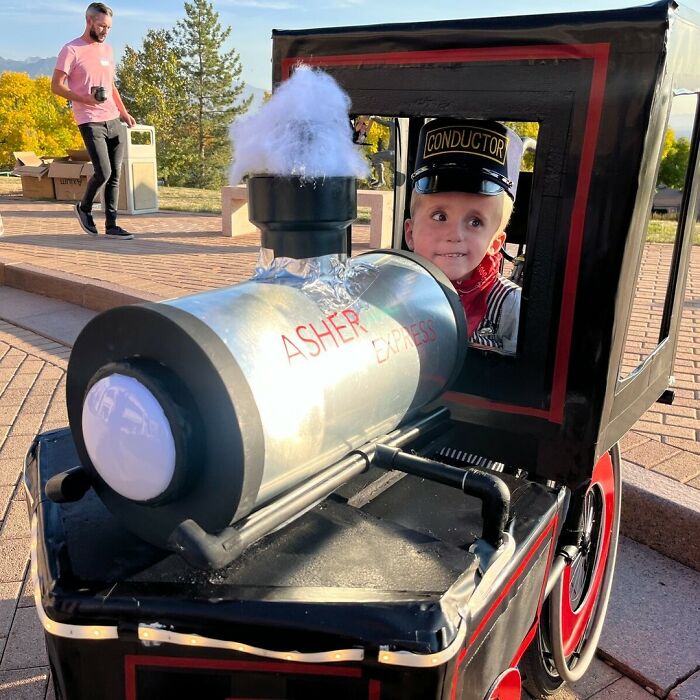 A creative Halloween costume for people with disabilities featuring a child in a train engine wheelchair.