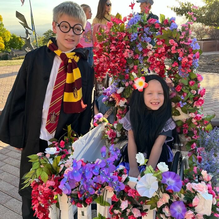 Boy in Harry Potter costume next to girl in floral wheelchair costume showing creative people with disabilities.