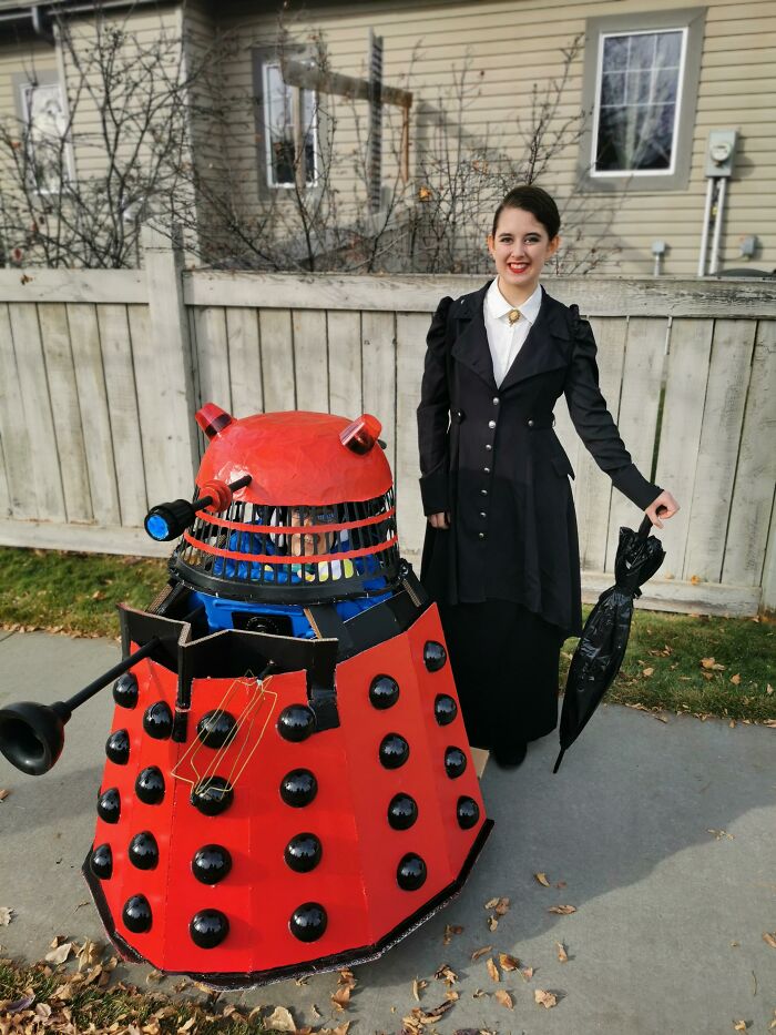 Child in custom red Dalek wheelchair costume outdoors alongside woman, showcasing creative people with disabilities