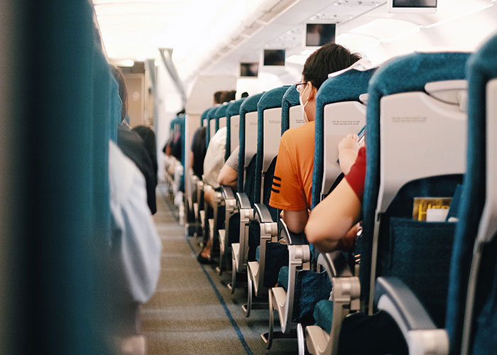 Passengers seated inside airplane cabin during flight