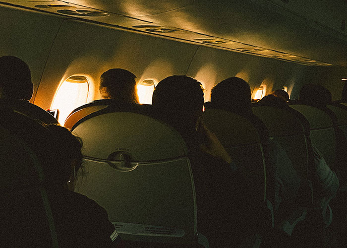 Passengers seated inside airplane cabin during flight
