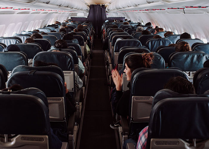 Full airplane cabin with seated passengers on flight